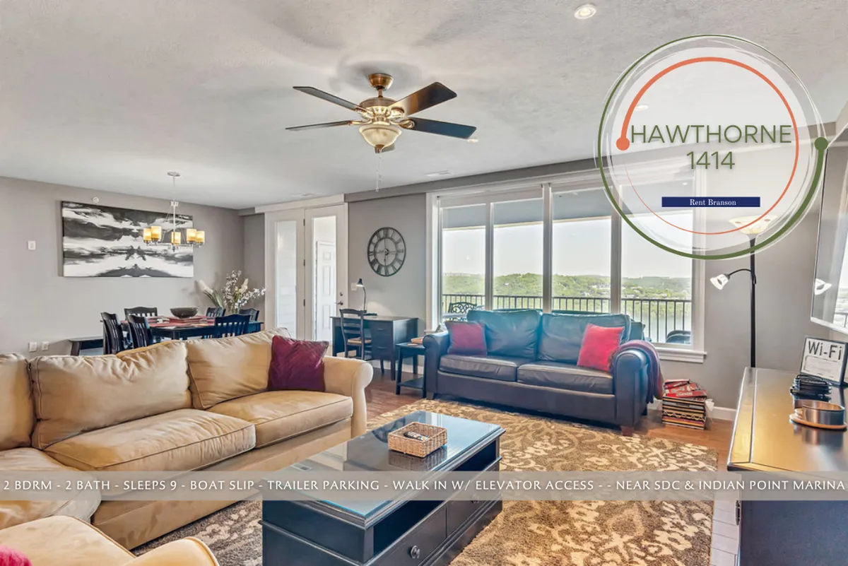 This interior image features comfortable sofas and a dining area seamlessly connected in an open-concept space. Large windows along one wall flood the room with natural light, offering views to the outdoors. Artwork on the wall adds a touch of style, while the arrangement encourages relaxation, gathering, and conversation.